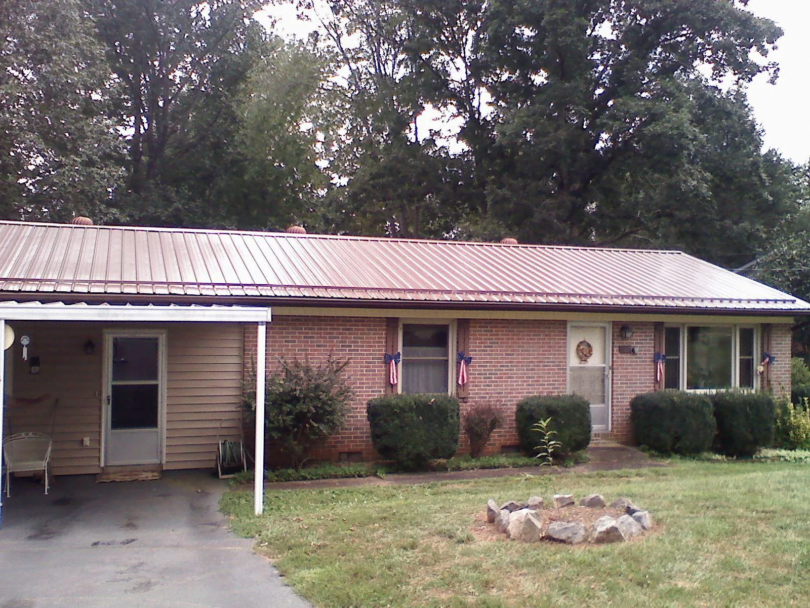 Bronze metal roof and carport on a brick ranch home — Roof Repair work by our crew in Marathon